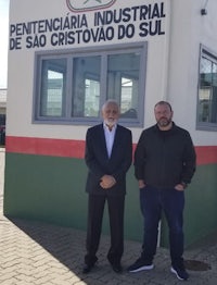 two men standing in front of a sign that says pentaneira industrial